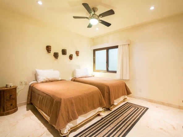 Beachfront condo for sale in Playa del Carmen – bedroom with two beds and both natural and artificial lighting