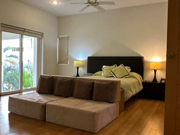 House for sale in Lagos del Sol, Cancun – bright bedroom with hardwood floor and warm lighting