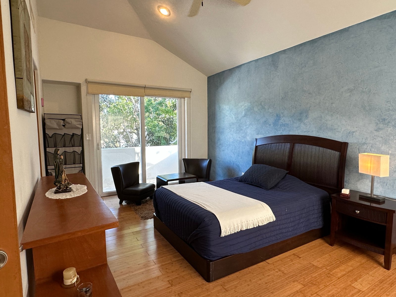 House for sale in Lagos del Sol, Cancun – bright bedroom with textured blue accent wall and private balcony at the rear