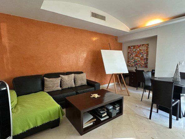House for sale in Lagos del Sol, Cancun – living room with sofa, coffee table, and easel in a bright setting