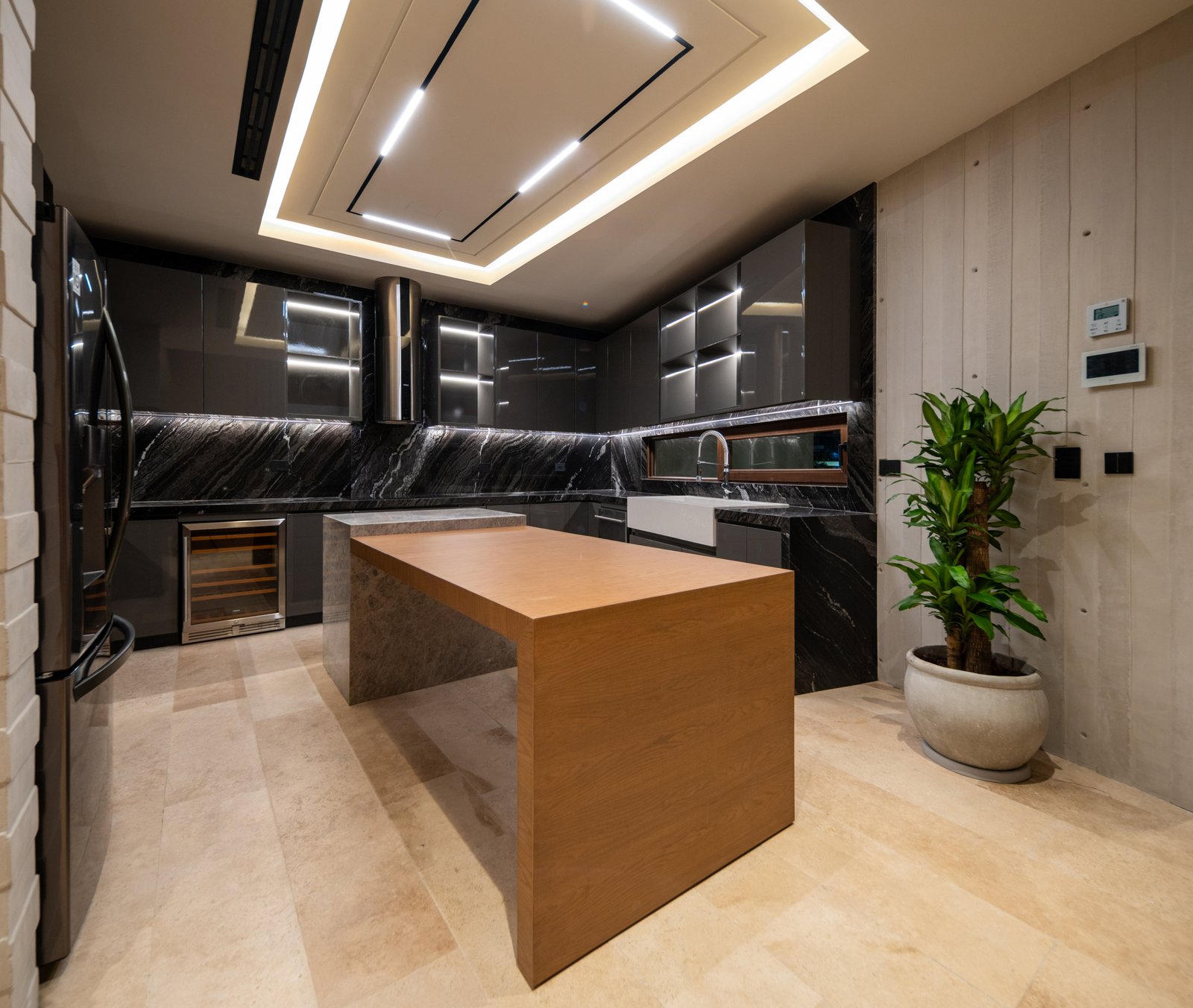 House for sale in Puerto Cancún - kitchen with central island, black marble countertops and contemporary ceiling lighting