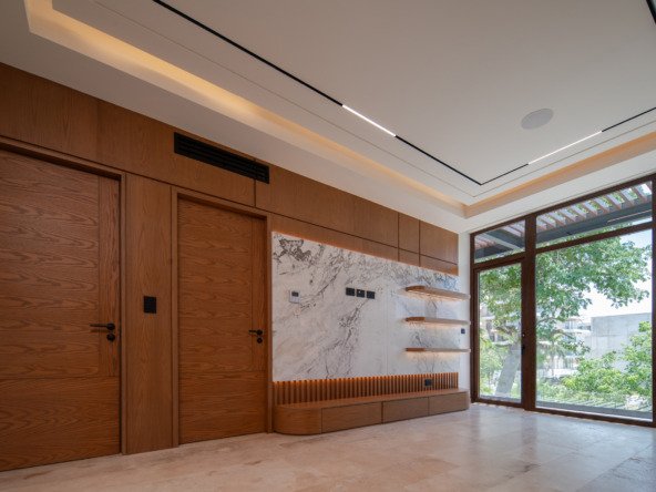 House for sale in Puerto Cancun – bedroom with elegant wood paneling, marble wall and large windows.