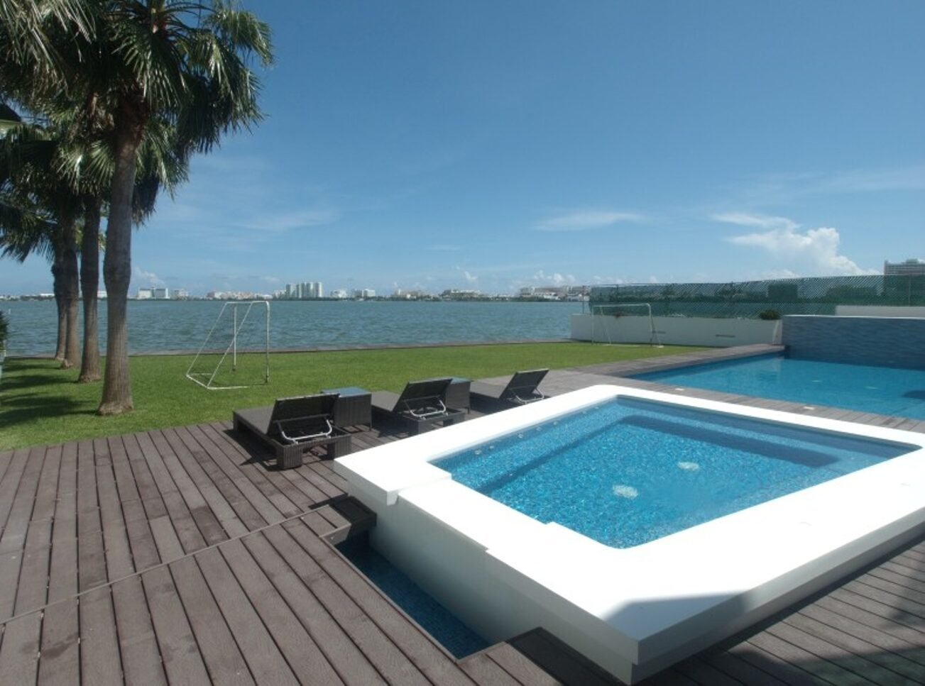 House for sale on Isla Dorada, Cancún – pool with lagoon view and hotels in the background