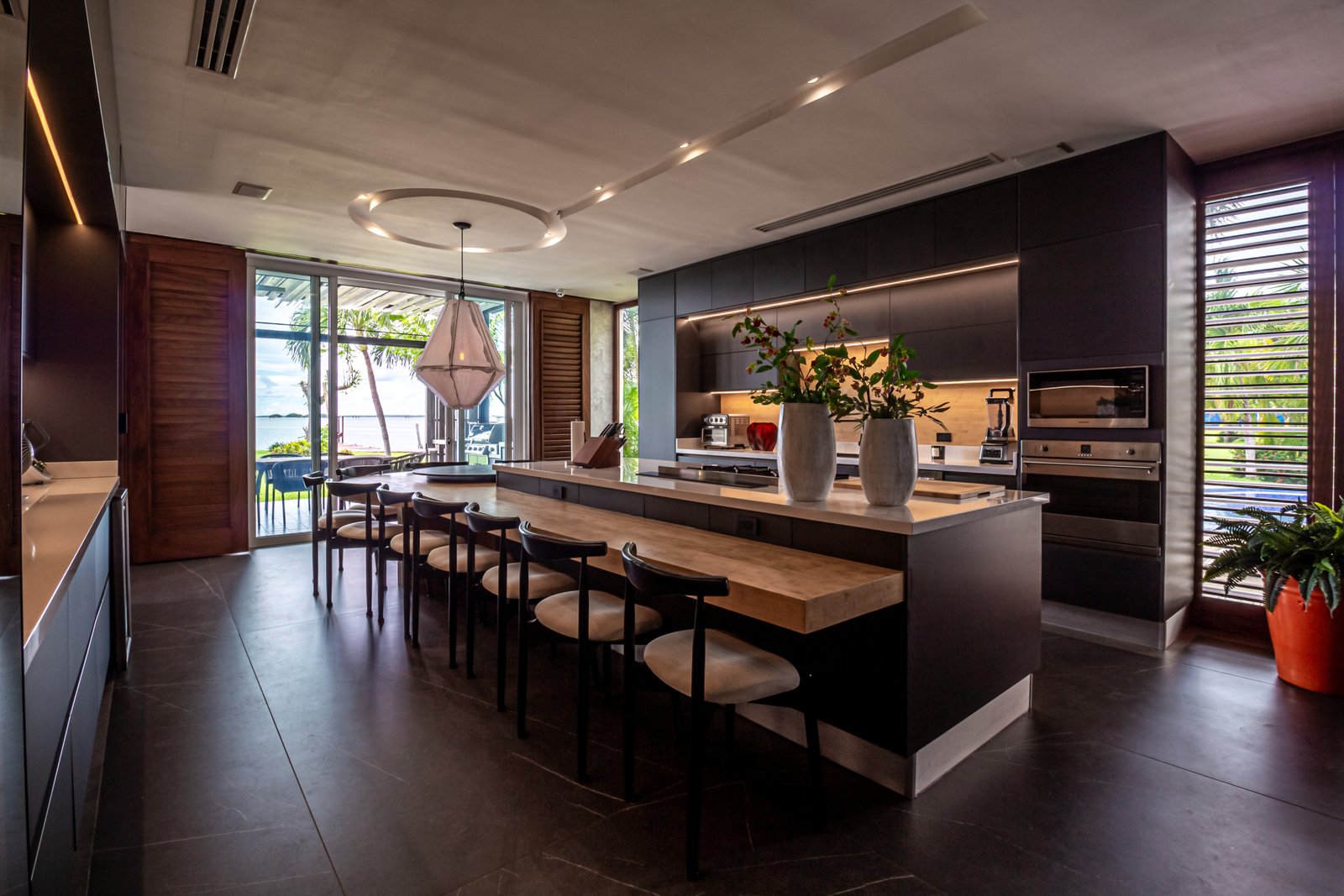 House for sale Isla Dorada Hotel Zone Cancún – kitchen bar, at the back the full kitchen with dark details