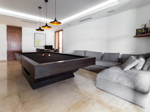 House for sale Isla Dorada hotel zone Cancún—game room with a modern dark-wood billiard table and pendant lights