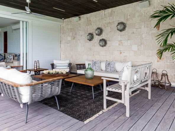 House for sale Isla Dorada hotel zone Cancun – covered outdoor area with white sofas, rattan chairs and wooden tables