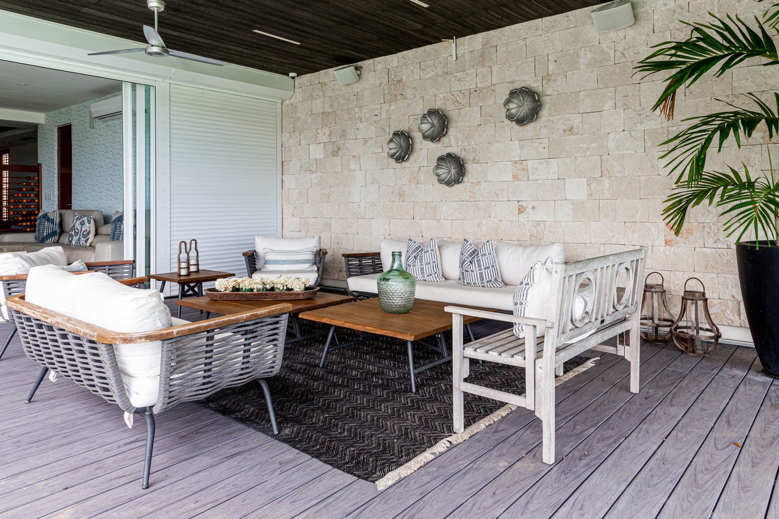 House for sale Isla Dorada hotel zone Cancun – covered outdoor area with white sofas, rattan chairs and wooden tables