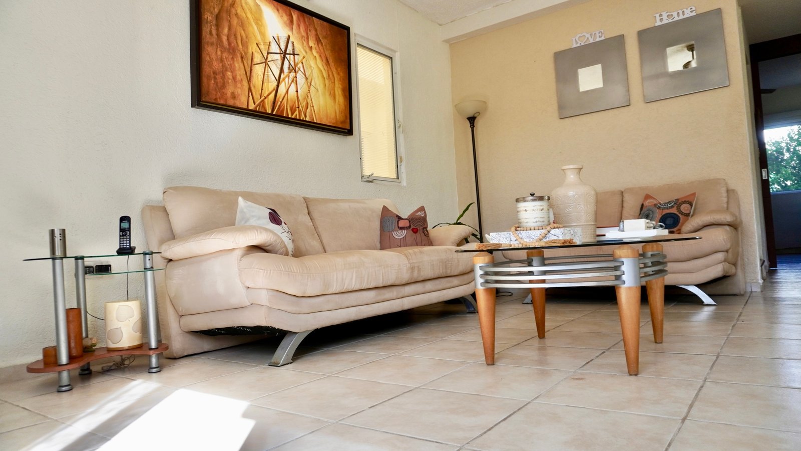 Apartment for sale in downtown Cancun - Living room with neutral-toned sofas and glass coffee table