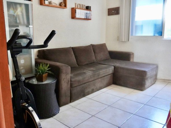 Apartment for sale in downtown Cancun - Living room with brown sofa. Window with exterior view