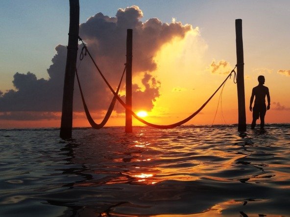 Land for sale on Holbox Island – sunset over the sea, with hammocks over the water