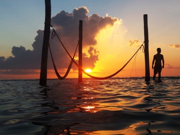 Land for sale on Holbox Island - sunset over the sea, with hammocks over the water